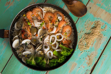 Stewed seafood rice on green wood background