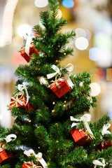 Picture of decorated Christmas tree with red gift boxes in store .