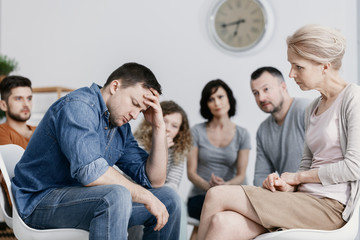 Man with headache and alcoholism problem and psychotherapist during meeting