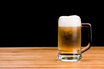 Glass of beer on wood table isolated on black background , drinking alcohol celebration object concept design