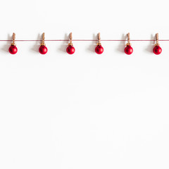 Christmas composition. Garland made of red balls on white background. Christmas, winter, new year concept. Flat lay, top view, copy space, square