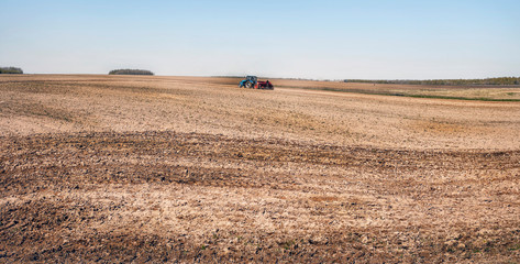 the tractor in the field plows the earth