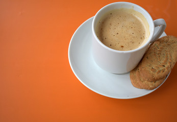 Cup of coffee on orange background.