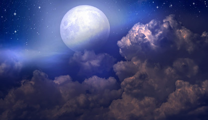 The full moon between the clouds in the night sky