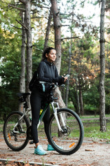Fototapeta na wymiar Smiling young woman riding at the park