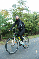 Obraz premium Smiling young woman riding at the park