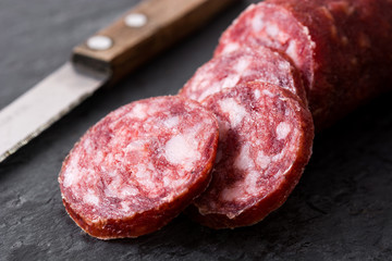 Cold meat chorizo on black slate background. Close up
