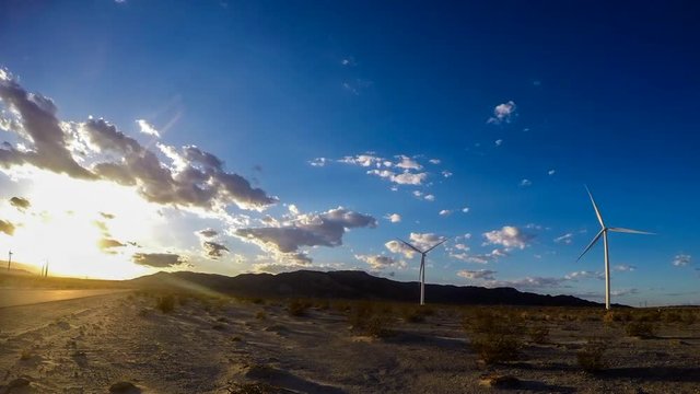 A time-lapse of a wind turbine farm in the middle of a beautiful sunset in the desert of Ocotillo California.