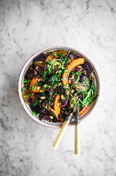 Quinoa lentil salad with rucola, roasted beets, pumpkin, apple, and red onion