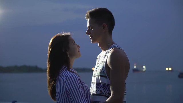 Nice girl and her boyfriend smiling and talking cheery on a quay  