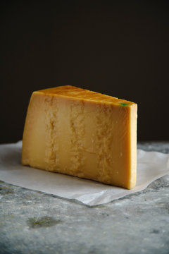 A block of parmesan cheese on metallic surface