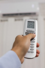 hand holds a remote control of air conditioner