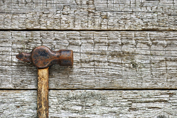 Old hammer on the rough wooden boards. Copy space. Flat lay.