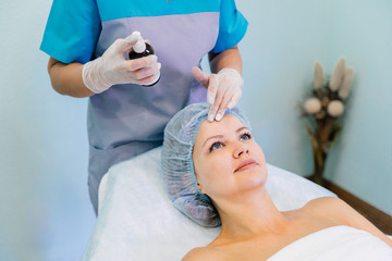 Young pretty woman enjoying face massage procedure