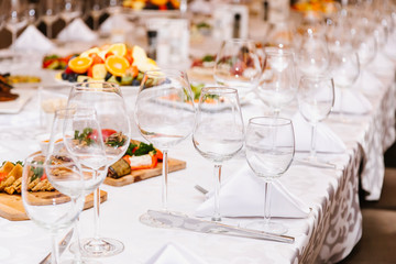 Fototapeta na wymiar Table setting for many people, wine glasses