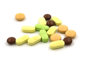 Multicolored tablets and pills on a white background
