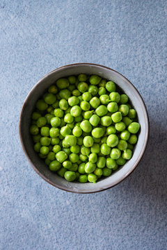 Overhead view of shelled green peas in bowl