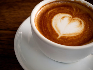 Hot coffee with soft bubble on old wooden boards.