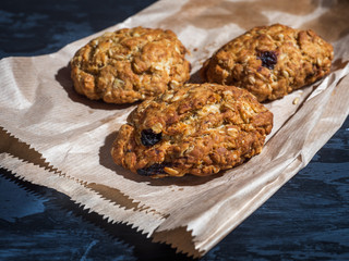Oatmeal raisin cookies on a paper bag on a gray background