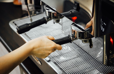 Barista's hand using espresso machine