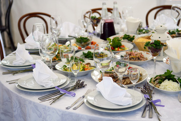 Wedding tables with food for the Banquet. Interior in soft colors for guests at the party.