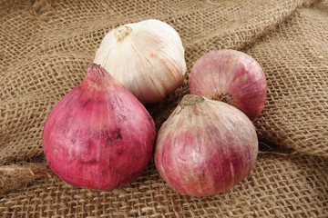 Onions on a brown rug background.