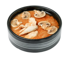 Spicy kimchi soup with mushrooms and chicken fillet in black bowl. Isolated on white background. Traditional menu of asian dishes.