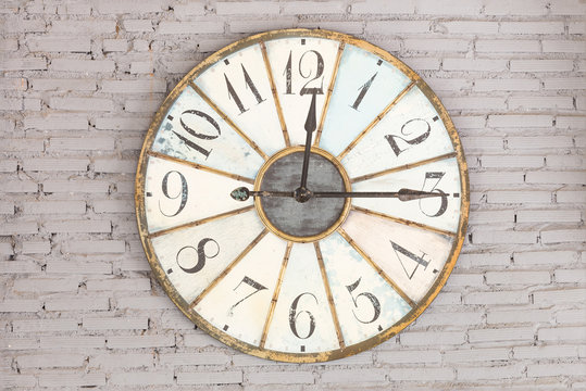 Retro clock showing twelve fifteen on the wall