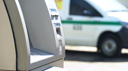Automated teller machine standing against cash-in-transit vehicle, banking