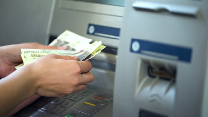 Female counting Russian rubles withdrawn from ATM, 24h service, easy banking