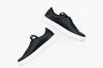 Pair of new black leather sneakers isolated on white background