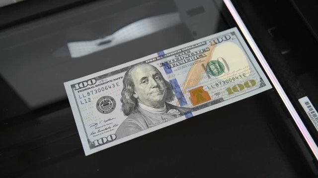 $100 being copied from the scanner. Counterfeiters. Money and banknotes.
