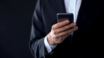 Businessman checking meeting calendar online, texting message on smartphone