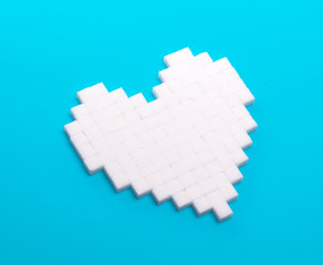 Heart of sugar cubes, blue background