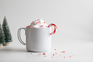 Candy canes in white mug and small Christmas tree