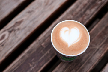 Cup of fresh cappuccino on wooden background.