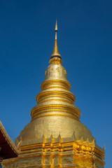 Fototapeta premium Wat Phra That Hariphunchai The province Lampoon of Thailand. There is a statue of Kruba Srichai in the temple.The temple has a golden pagoda. And green lawns. And the beautiful temple gazebo.