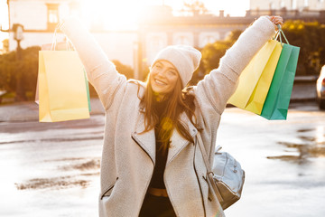 Cheerful young woman dressed in autumn coat and hat