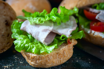 Homemade sandwich with ham and vegetables on wooden background