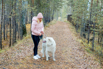 A pretty woman is walking her dog