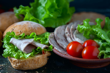 Homemade sandwich with ham and vegetables on wooden background