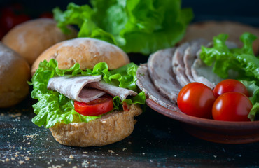 Homemade sandwich with ham and vegetables on wooden background