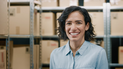 Portrait of the Beautiful Female Warehouse Inventory Manager Standing and Smiling Charmingly....