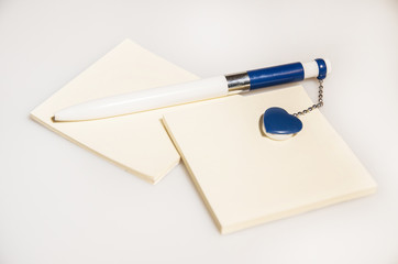 Blue pen with heart and blank paper on isolated background