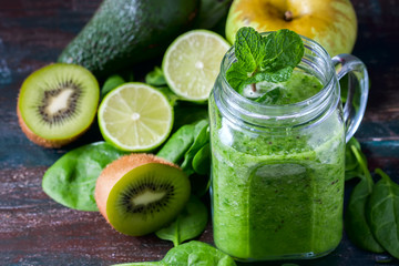 Healthy green smoothie on a dark wooden background. Vegetarian food concept, detox, fitness.