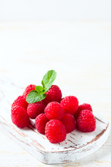 Ripe fresh raspberries on a wooden background.