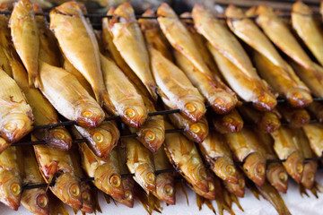 Smoked fish on a stick on a counter in the market