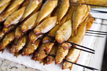 Smoked fish on a stick on a counter in the market