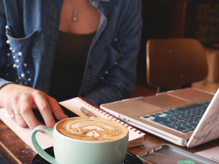 Girl Working on Laptop with Notepad and Coffee 