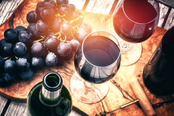 Setting with bottles of red wine and glasses